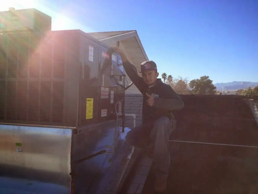 HVAC technician performing Air Duct Repair on a rooftop unit in Cumberland